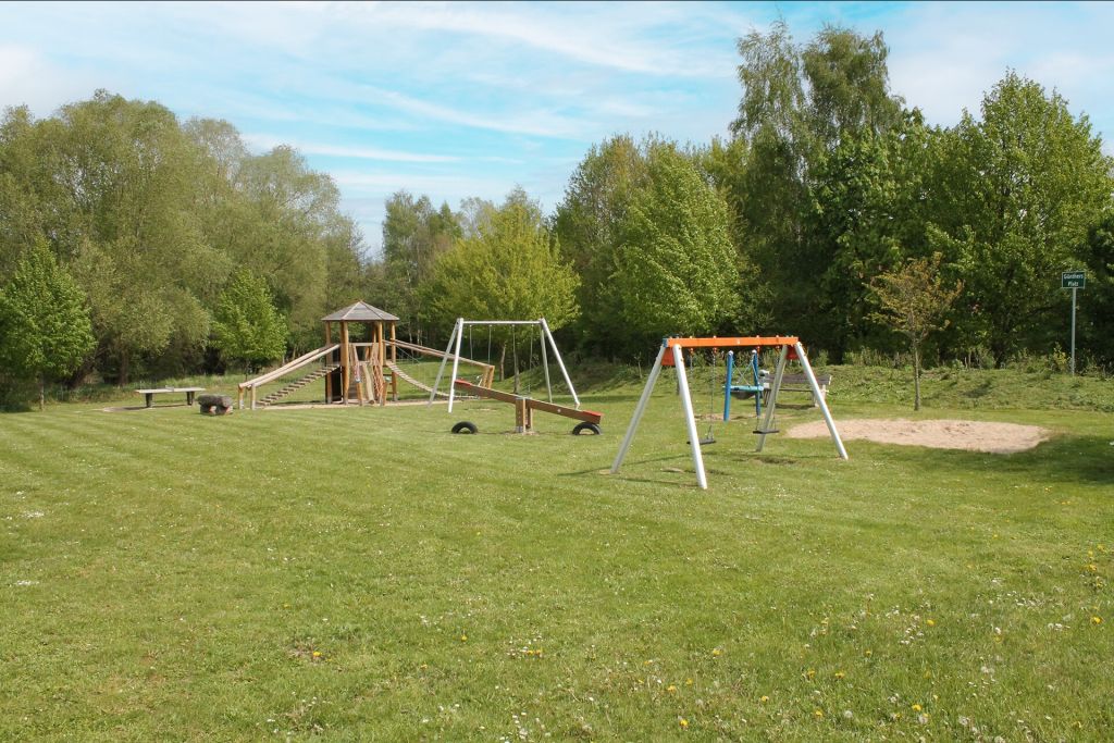 Urlauberdorf - Blick auf den Spielplatz hinter den Häusern 54-55