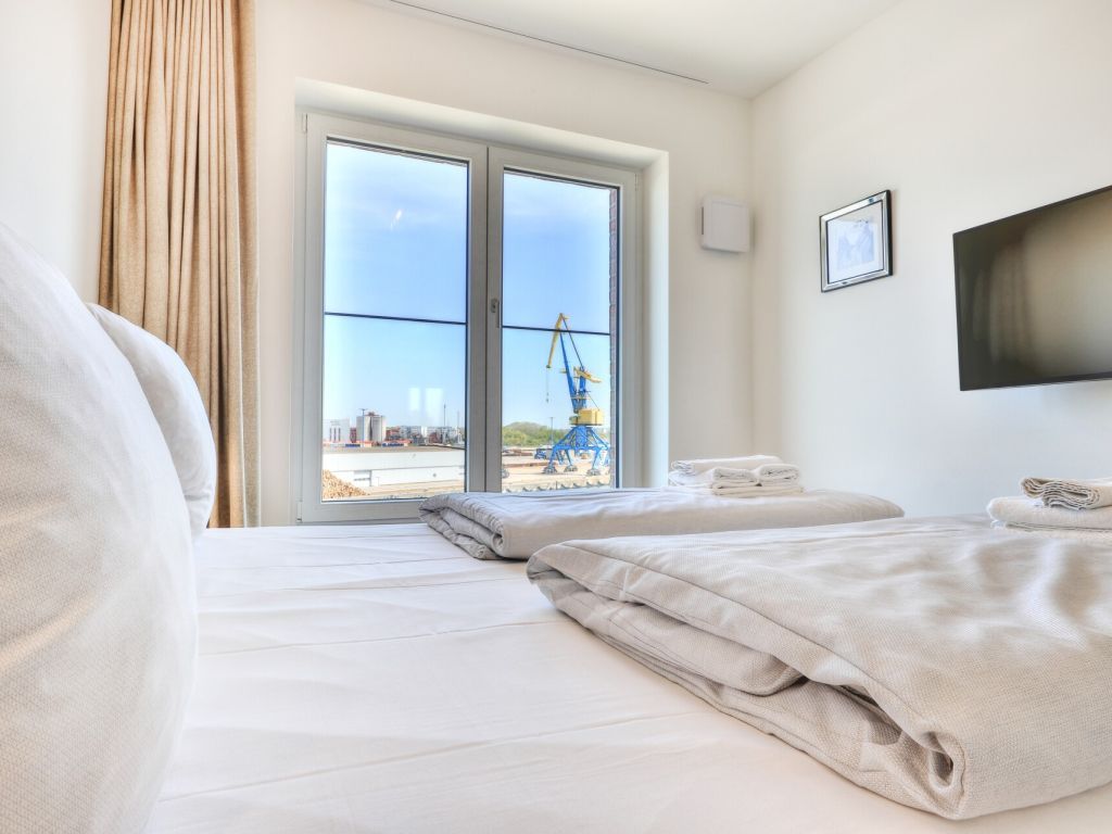 Hafenspitze App. 33 - Blick in ein Schlafzimmer mit Boxspringbett und TV