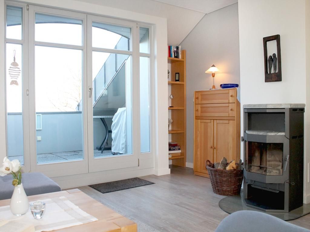 Villa Seegarten App.11- Wohnbereich mit Kamin und Balkonzugang (nord)