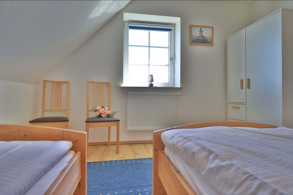 Wellenreiter Ferienhaus - Blick in das eine Schlafzimmer mit 2 Einzelbett im OG