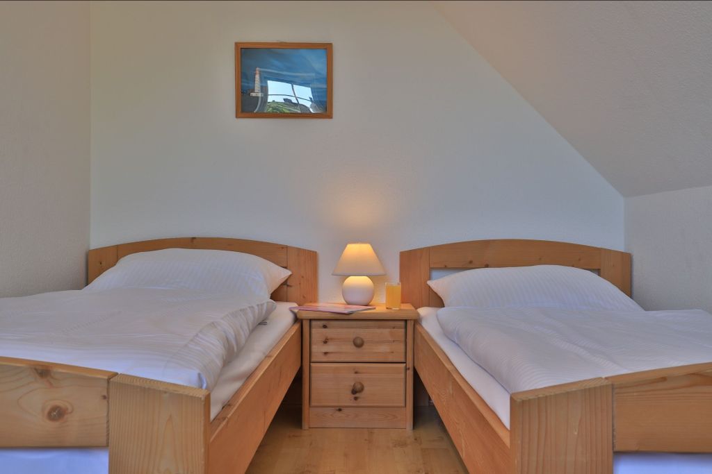 Wellenreiter Ferienhaus - Blick in das eine Schlafzimmer mit 2 Einzelbett im OG