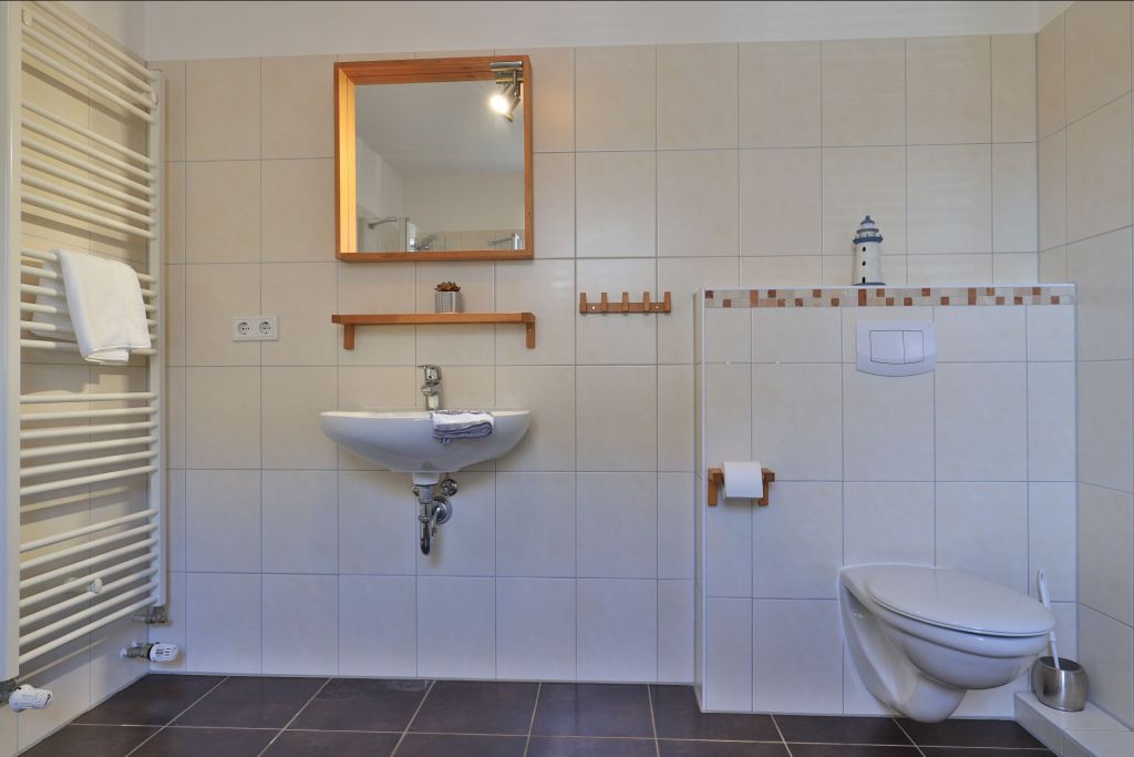 Wellenreiter Ferienhaus - Blick in das Duschbad mit Waschmaschine im EG