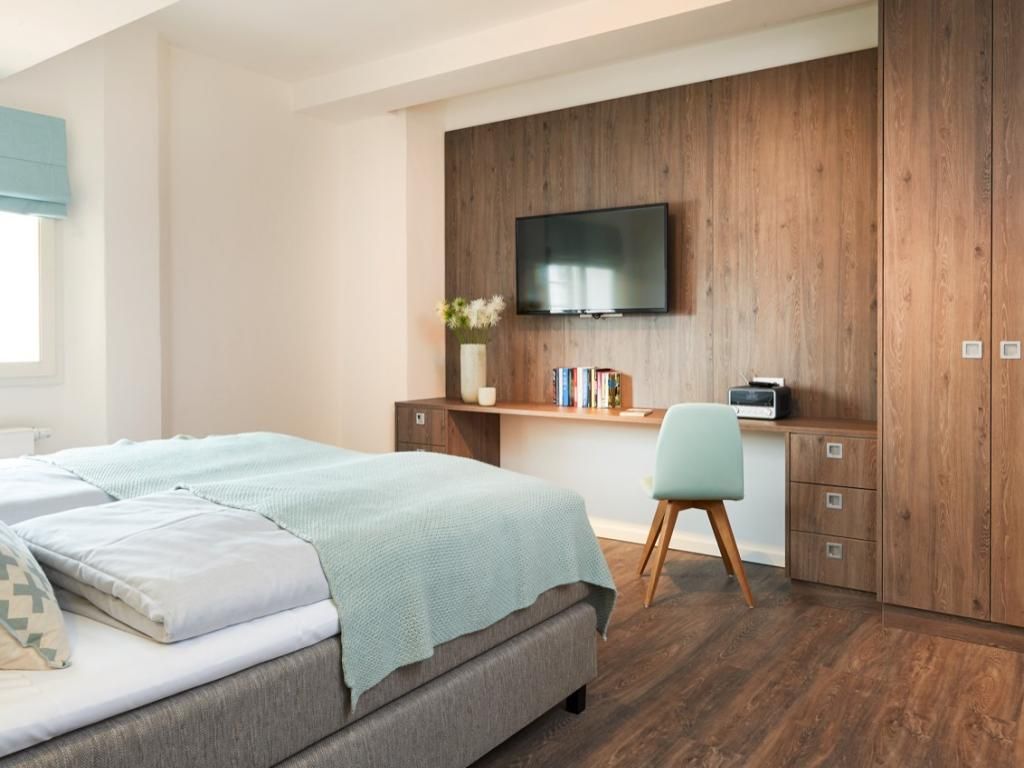 Ohlerich Speicher App. 04 - Blick in das Schlafzimmer mit TV und Arbeitsbereich